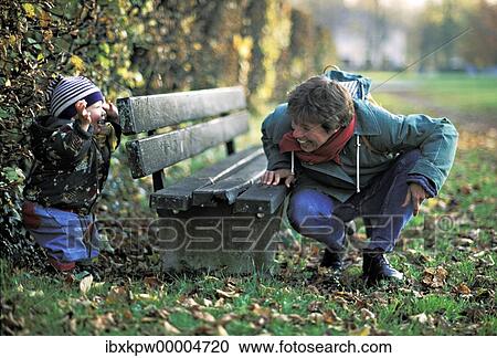 A mother and her one-year-old son playing hide-and-seek behind a park bench View Large Photo Image Stock Image - A mother and her one-year-old son playing hide-and-seek behind a park bench. Fotosearch