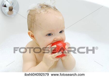 Stock Photo - Baby girl, 11 months, while bathing, playing with a ball, Germany, Europe. Fotosearch
