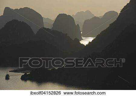 Boat on the water at sunset in the Ha Long Bay or Vinh Ha Long, limestone cliffs, UNESCO World Heritage Site, Gulf of Tonkin, North Vietnam, Vietnam, Asia View Large Photo Image Stock Photograph - Boat on the water at sunset in the Ha Long Bay or Vinh Ha Long, limestone cliffs, UNESCO World Heritage Site, Gulf of Tonkin, North Vietnam, Vietnam, Asia. Fotosearch