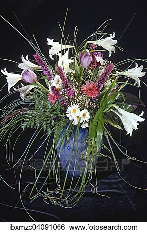 Stock Photograph - Bouquet of flowers in a vase against a dark backdrop. Fotosearch