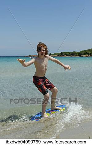 Stock Photograph Of Boy Surfing With His Boogie Board Beach Boy Surfing With His Boogie Board Beach Or Skimboard On The Bay Of Rondinara Southeast Coast Corsica France Europe