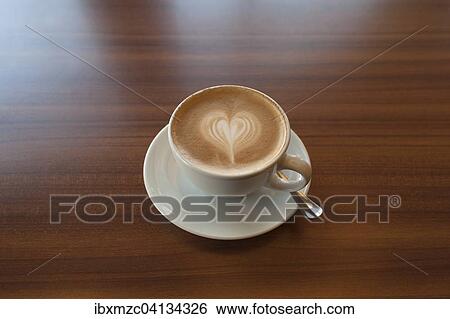 Cappuccino with heart on a wooden table View Large Photo Image Stock Photograph - Cappuccino with heart on a wooden table. Fotosearch