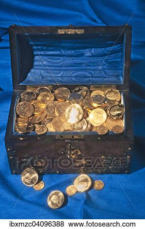 Stock Photo - Chest filled with gold coins, on blue fabric. Fotosearch