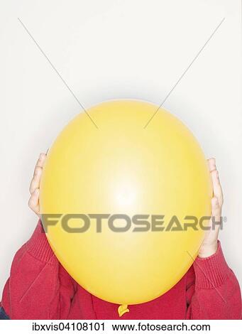 Child holding a yellow balloon in front of face View Large Photo Image Stock Image - Child holding a yellow balloon in front of face. Fotosearch
