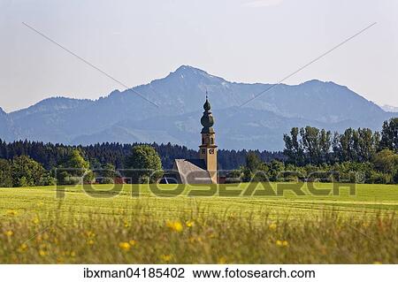 Stock Image - Church of St. John Baptist, Hochgern mountain behind, Brunning, Chiemgau, Upper Bavaria, Bavaria, Germany, Europe. Fotosearch
