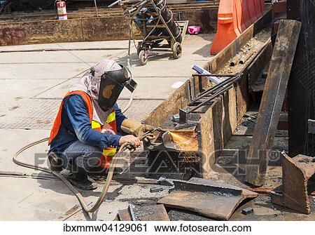 Stock Image - Construction worker welding a steel beam on a construction site, Bangkok, Thailand, Asia. Fotosearch