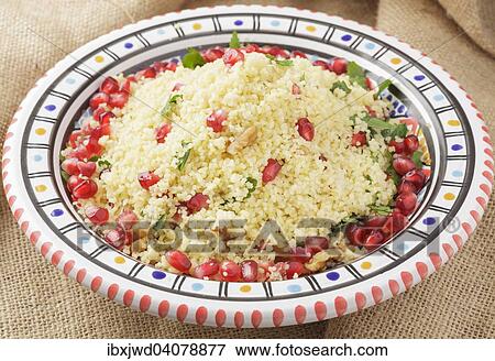 Couscous with pomegranate seeds, walnuts and parsley View Large Photo Image Stock Photo - Couscous with pomegranate seeds, walnuts and parsley. Fotosearch