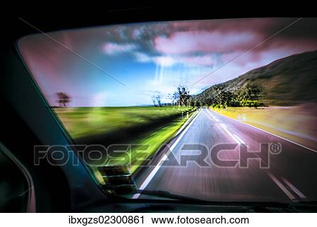 Stock Image - Driving under the influence of drugs, danger to road traffic, driving on the left, view from inside a car on the road, driving fast, West Coast, New Zealand, Oceania. Fotosearch