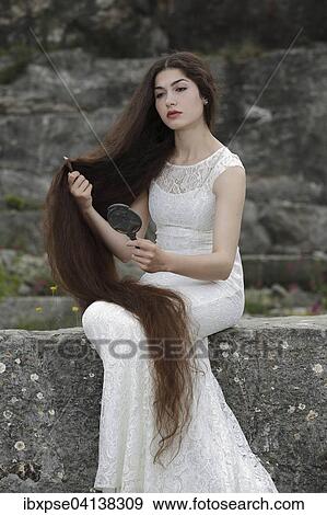 Enactment of the painting Lady Lilith by Dante Gabriel Rossetti, young woman in a white dress, combing her hair and looking in the mirror View Large Photo Image Stock Photo - Enactment of the painting Lady Lilith by Dante Gabriel Rossetti, young woman in a white dress, combing her hair and looking in the mirror. Fotosearch