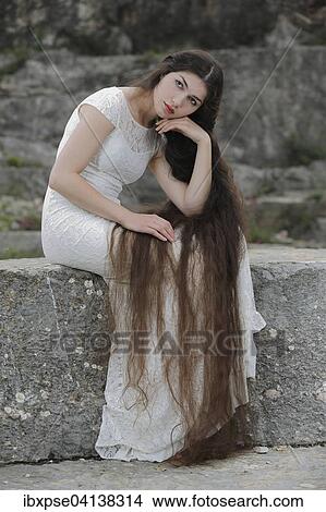 Picture - Enactment of the painting Reverie by Dante Gabriel Rossetti, young woman in a white dress. Fotosearch