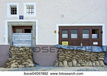 Stock Image - Flood control measures, sandbags and a protective wall of steel slats in front of a front door and a garage door, historic centre, Passau, Lower Bavaria, Bavaria, Germany, Europe. Fotosearch