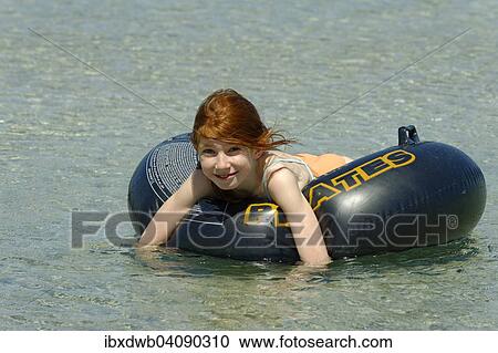 Girl in a big floating tyre in the turquoise waters in the Bay of Rondinara, southeast coast, Corsica, France, Europe View Large Photo Image Stock Image - Girl in a big floating tyre in the turquoise waters in the Bay of Rondinara, southeast coast, Corsica, France, Europe. Fotosearch