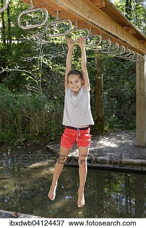 Stock Photo - Girl swinging above water, Auwaldlehrpfad trail, Walderlebniszentrum Ziegelwies, near Fussen, Ostallgau, Swabia, Bavaria, Germany, Europe. Fotosearch