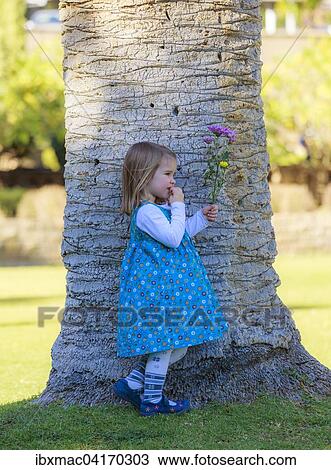 Girl with bouquet leaning against palm trunk, Windhoek, Namibia, Africa View Large Photo Image Stock Image - Girl with bouquet leaning against palm trunk, Windhoek, Namibia, Africa. Fotosearch