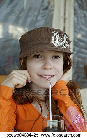 Stock Photography - Girl with cap drinking with a straw, Corsica, France, Europe. Fotosearch