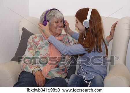 Granddaughter and grandmother listening to music through headphones, digital music, Bavaria, Germany, Europe View Large Photo Image Stock Image - Granddaughter and grandmother listening to music through headphones, digital music, Bavaria, Germany, Europe. Fotosearch