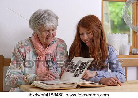 Granddaughter and grandmother looking at a photo album, Bavaria, Germany, Europe View Large Photo Image Stock Photo - Granddaughter and grandmother looking at a photo album, Bavaria, Germany, Europe. Fotosearch