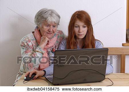 Stock Photography - Granddaughter and grandmother using laptop, Bavaria, Germany, Europe. Fotosearch