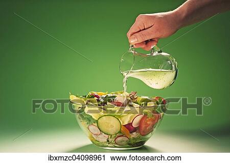 Hand pouring herbal vinegar into a bowl filled with salad View Large Photo Image Stock Image - Hand pouring herbal vinegar into a bowl filled with salad. Fotosearch