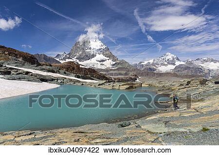 Hiker at glacier lake on the way to the Gandegg hut, the Matterhorn behind, Trockener Steg area, Zermatt, Canton of Valais, Switzerland, Europe View Large Photo Image Stock Image - Hiker at glacier lake on the way to the Gandegg hut, the Matterhorn behind, Trockener Steg area, Zermatt, Canton of Valais, Switzerland, Europe. Fotosearch