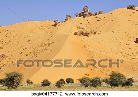 Stock Image - Hill almost fully covered with sand from a sand dune, route from Atar to Tidjikja, Adrar region, Mauritania, Africa. Fotosearch