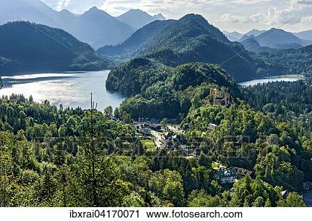 Stock Image - Hohenschwangau Castle, lake Alpsee, lake Schwansee, Tannheim Mountains behind, Schwangau, Konigswinkel, Ostallgau, Allgau, Swabia, Bavaria, Germany, Europe. Fotosearch