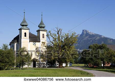 Stock Photograph - Laurentiuskirche church with Mt Schafberg, St. Lorenz, Mondseeland region, Salzkammergut, Upper Austria, Austria, Europe. Fotosearch