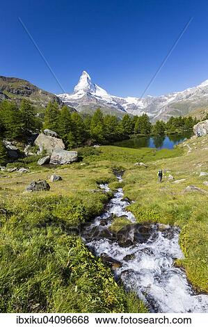 Stock Photo - Man hiking at Grindjisee lake, the Matterhorn at the back, Zermatt, Canton of Valais, Switzerland, Europe. Fotosearch