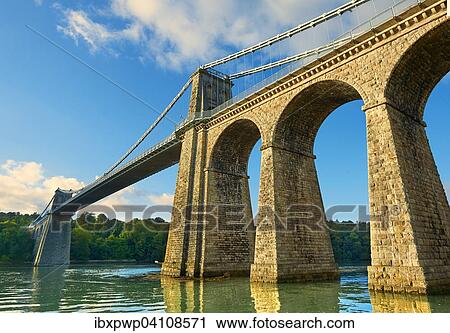 Stock Image - Menai Suspension Bridge, completed in 1826, crossing the Menai Strait between the island of Anglesey and the mainland of Wales, United Kingdom, Europe. Fotosearch