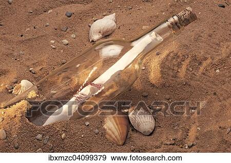 Message in a bottle, bottle in the sand View Large Photo Image Stock Photo - Message in a bottle, bottle in the sand. Fotosearch