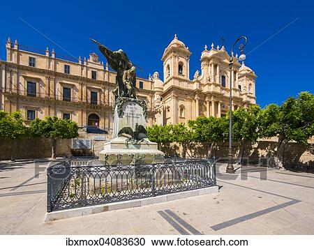 Stock Image - Palazzo Nicolaci with war memorial, at the back the restored baroque chuch Noto Cathedral, Noto, Val di Noto, UNESCO World Heritage Site, Province of Syracuse, Sicily, Italy, Europe. Fotosearch