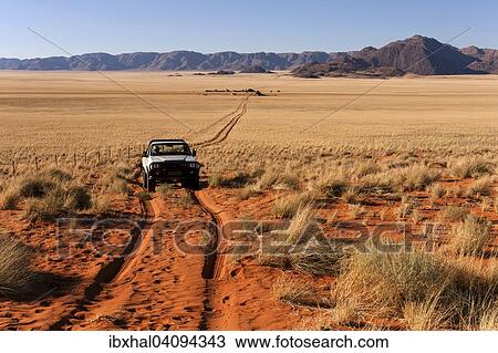 Pick-up driving through desert landscape behind the Tiras Mountains, Namibia, Africa View Large Photo Image Stock Image - Pick-up driving through desert landscape behind the Tiras Mountains, Namibia, Africa. Fotosearch