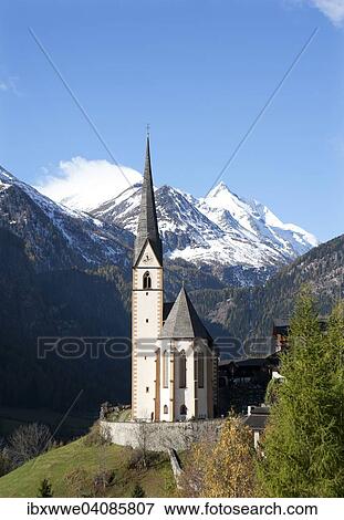 Stock Photo - Pilgrimage church of St. Vincent with Mt Grossglockner, village of Heiligenblut am Grossglockner, Molltal valley, High Tauern National Park, Carinthia, Austria, Europe. Fotosearch