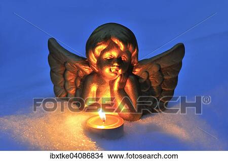 Porcelain figure, angel in the snow, with a tea light View Large Photo Image Picture - Porcelain figure, angel in the snow, with a tea light. Fotosearch