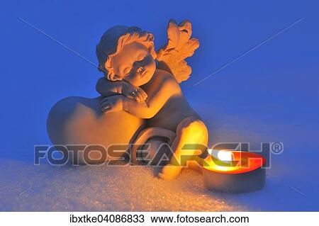 Porcelain figure, angel in the snow, with a tea light View Large Photo Image Stock Image - Porcelain figure, angel in the snow, with a tea light. Fotosearch