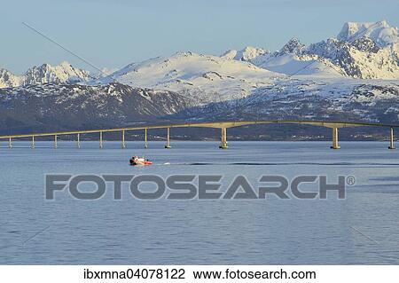 Red boat in front of Hadsel Bridge across the strait, at the back the snow-capped mountains of Hinnoya island, Langoysund, near Stokmarknes, Nordland, Vesteralen, Norway, Europe View Large Photo Image Stock Image - Red boat in front of Hadsel Bridge across the strait, at the back the snow-capped mountains of Hinnoya island, Langoysund, near Stokmarknes, Nordland, Vesteralen, Norway, Europe. Fotosearch