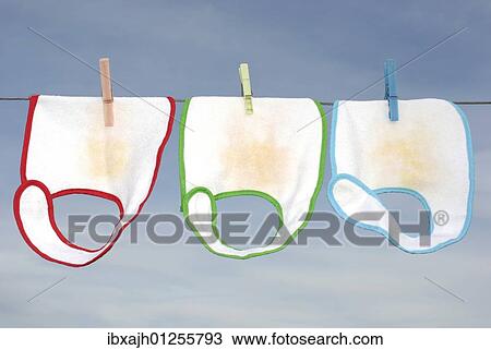 Stock Image - Red, green and blue baby bibs laundry drying. Fotosearch