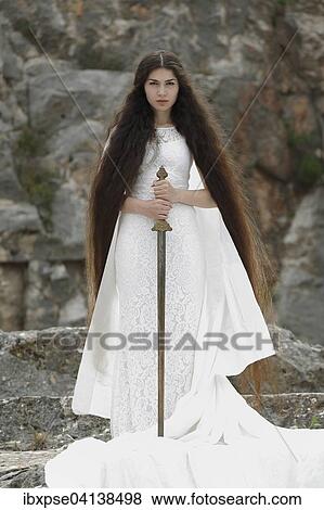Stock Photo - Reminiscence to Joan of Arc, Jeanne d'Arc, young woman in a white dress with a sword. Fotosearch