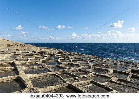 Stock Image - Sandstone formations on the coast, sea salt extraction in salt pans, Xlendi, Gozo, Malta, Europe. Fotosearch