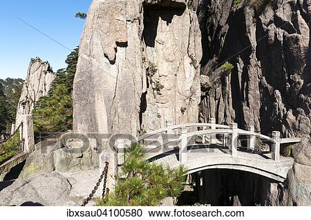 Stock Image - Small arch bridge spanning deep canyon of granite rocks, Mount Huangshan, Huang Shan, Anhui Province, China, Asia. Fotosearch