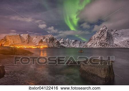Small aurora with clouds, rocks by the ocean, small town and mountains at the back, Hamnoy Island, Lofoten, Norway, Europe View Large Photo Image Stock Photograph - Small aurora with clouds, rocks by the ocean, small town and mountains at the back, Hamnoy Island, Lofoten, Norway, Europe. Fotosearch