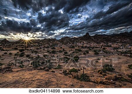 Small village of Aguard Oudad with brightly painted houses in front of the rock Chapeau Napoleon, dramatic clouds, evening, Tafraoute, Anti Atlas, Southern Morocco, Morocco, Africa View Large Photo Image Stock Photo - Small village of Aguard Oudad with brightly painted houses in front of the rock Chapeau Napoleon, dramatic clouds, evening, Tafraoute, Anti Atlas, Southern Morocco, Morocco, Africa. Fotosearch