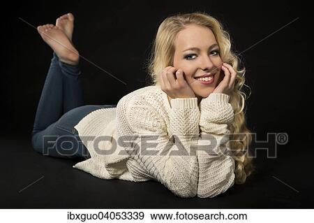 Smiling young woman lying on her stomach, head resting in her hands View Large Photo Image Stock Photo - Smiling young woman lying on her stomach, head resting in her hands. Fotosearch