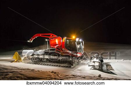 Picture - Snowcat planing ski slope with rope at night, Austria, Europe. Fotosearch