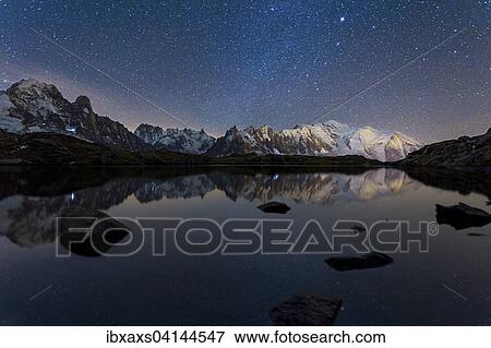 Stock Photo - Starry sky with Milky Way and Mont Blanc massif reflected in the Lac des Chesery, Chamonix, Rhone-Alpes, France, Europe. Fotosearch