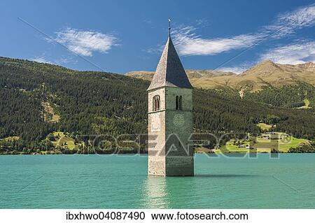Stock Image - Steeple, bell tower of the submerged church of the village of Alt-Graun in Lake Reschen, or Reschensee Lake, Graun, Vinschgau, Curon Venosta, South Tyrol, Trentino-Alto Adige, Italy, Europe. Fotosearch