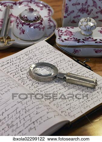 Stock Image - Still life with a handwritten diary, magnifying glass and antique bone china accessories. Fotosearch