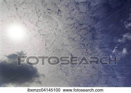 Stock Image - Sun hidden by slight cloud cover. Fotosearch