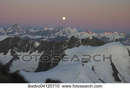 Stock Image - Sunrise by Sustenhorn with setting moon, Stein Glacier, Canton of Bern, Switzerland, Europe. Fotosearch
