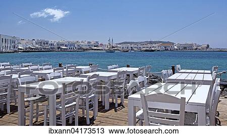 Stock Image - Tables and chairs at the harbour of Mykonos Town or Chora, Mykonos, Cyclades, Greece, Europe. Fotosearch